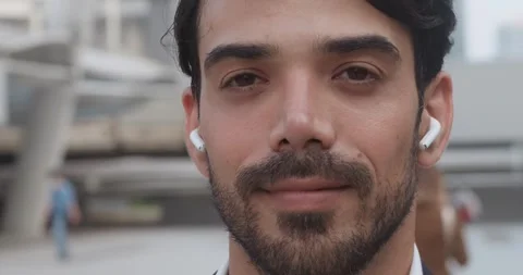 Middle eastern man with earphones looking at camera close up face look at camera Stock Footage 312500132