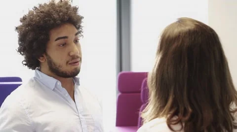 Middle Eastern Man having a conversation with female colleague in office Stock Footage 67346562