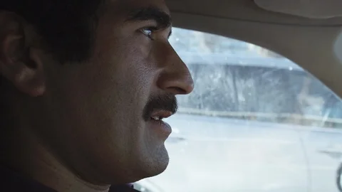 Middle eastern man laughing in car while driving in stressful city traffic Stock Footage 89188772
