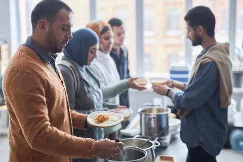 Middle Eastern Man Receiving Free Meals at Soup Kitchen Stock Photos