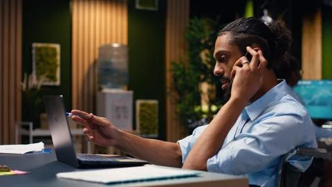 Middle eastern man with reduced mobility in wheelchair on phone call Stock Photos