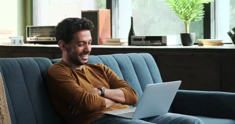 Middle Eastern Man Using Laptop and Laughing on Sofa in the Living Room Stock-Footage 254505897