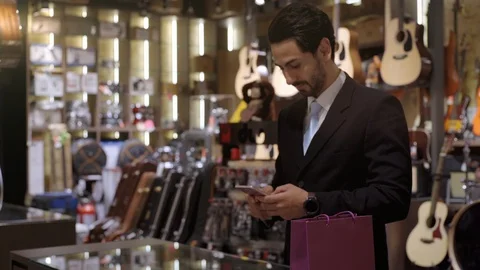 A Middle Eastern Man Using Mobile Phone To Purchase Product Stock Footage 120380068