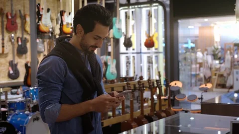 A Middle Eastern Man Using Mobile Phone To Purchase Product 库存影片 120380217