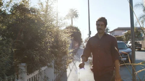 Middle eastern man walking up to apartment gate in California neighborhood Video stock 89225713