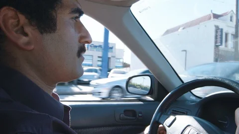 Middle eastern millennial concentrating on driving in city traffic Stock Footage 89189918