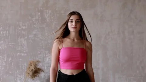 Middle Eastern model walking straight poses for the camera. Her hair is blowing  Stock Footage 228651217