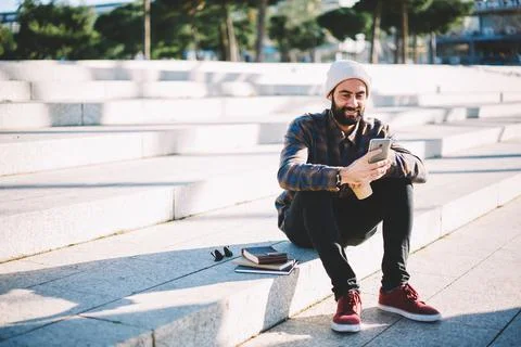 Middle Eastern student chatting with followers from social network via app on Stock Photos
