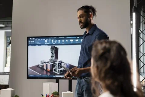 Middle eastern urban developer presenting blueprints master plan to colleagues Stock Photos