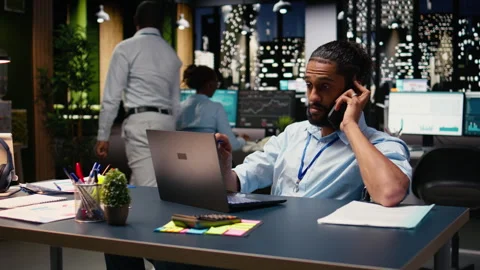 Middle Eastern wheelchair user engaged in phone call during office work Stock Footage 334040493