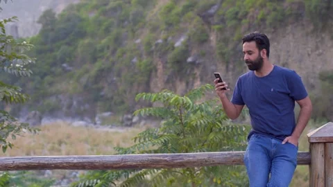 Middle eastern young man using mobile smart phone out doors making call Stock Footage 140287095