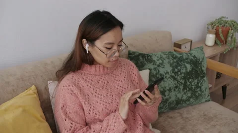 Middle Eastern young woman using smart phone surfing social media, playing Video stock 149570223