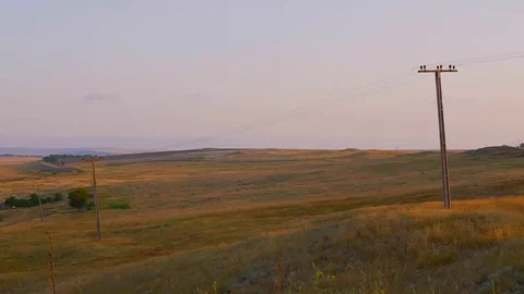 In the middle of a field of an electric pole with wires Stock Footage 85149505