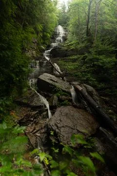 In the middle of the forest the long waterfall flows. Stock Photos
