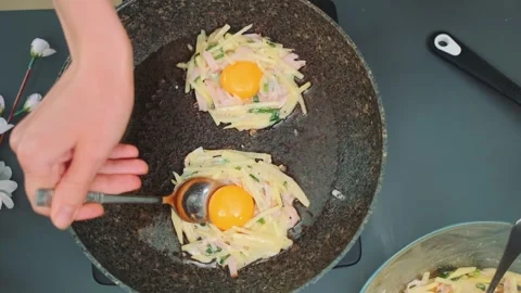 In the middle of the fried potatoes in the form of a nest, put the yolk Stock Footage 249450255