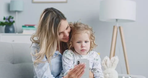 Middle plan of cute funny little kid girl having fun with mom enjoy using modern Stock Footage 132319997