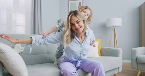 Middle plan of loving young mum playing piggybacking with cute little funny kid Stock Footage 132318222