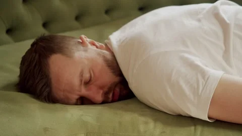 Middle plan a man falls on the sofa from fatigue face down and immediately falls Stock Footage 143708019