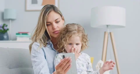 Middle plan of sweet curly little kid girl having fun with mom enjoy using Stock Footage 132320002