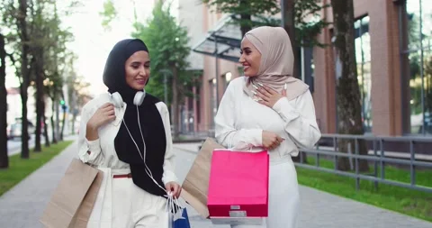 Middle plan of two young Arabic beautiful women in hijabs. Muslim females Stock Footage 139635577