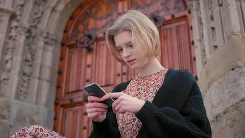 Middle plan of young blond short hair Caucasian girl having rest on city streets Stock Footage 105059505