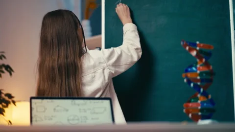 Middle school student writes an equation on the chalkboard during a math lesson Stock Footage 300277154