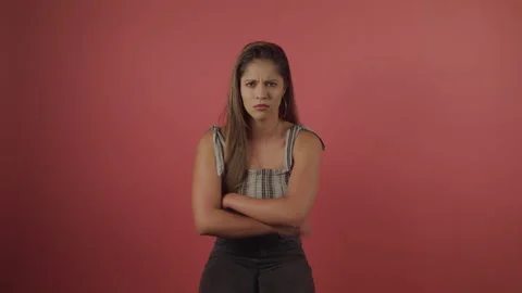 Middle shot of Grumpy Young Lady standing on red background in studio Stock Footage 208715875