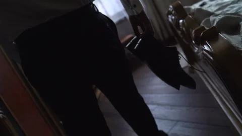 Middle shot of man carrying a pair of shoes. Young adult walking through the Stock Footage 148736231