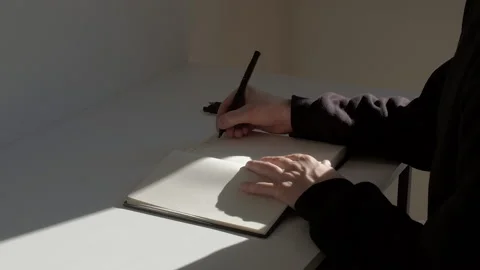 Middle shot: man writing text on English with pen on the white page of diary Video stock 229896802