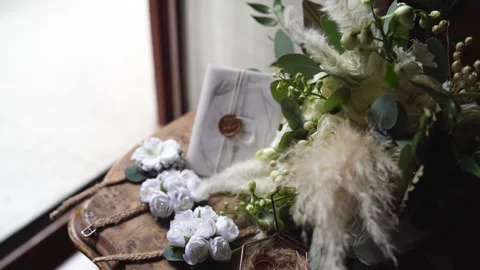 Middle shot of wedding details. White boutonnieres with flowers and jewelry box Stock Footage 148564145
