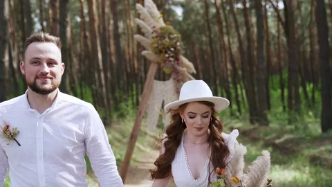 Middle shot. Young couple walking holding hands hugging in forest. Slow motion Stock Footage 204940895