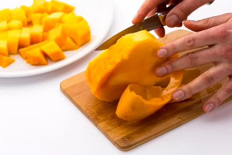 Middle third of a mango with its pit being peeled Stock Photos