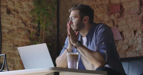 A middle view of thoughtful serious man in eyeglass sit with laptop thinking of Stock Footage 164674899