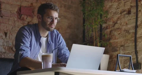 A middle view of thoughtful serious man in eyeglass sit with laptop thinking of Stock Footage 166587611