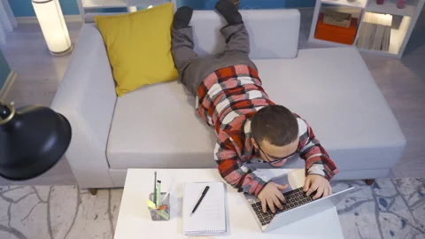 Midget man working on computer lying down at home. Stock Footage 230976836