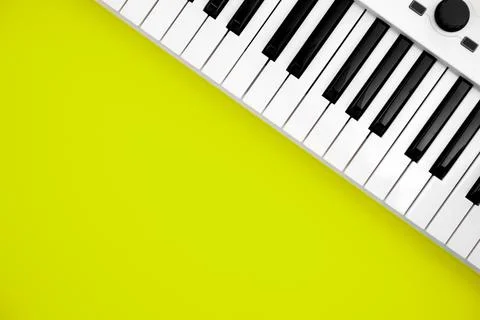 Midi keyboard on green background, flat lay, copy space. Stock Photos