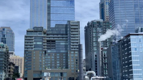 Midlevel view of sky scrapers and a smoke stack in downtown Seattle seen Stock Footage 116608637