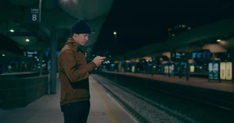 Midnight commuter wait for train on dark platform Stock Footage 149877020