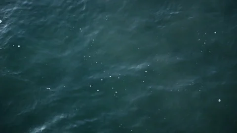 Midnight Green Ocean Waters Ripple from Above Until a Wave Crashes Through Stock Footage