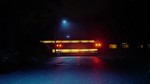 Midnight train passing railroad crossing in a misty forest Stock Footage 165225805