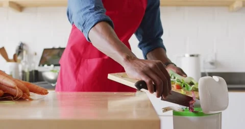 Midsection of african american man standing in kitchen and cleaning waste Stock Footage 338325121