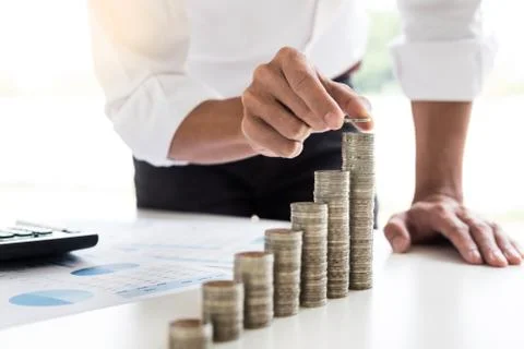 Midsection of businessman hand put stacking coins at on Increasing coin offic Stock-Fotos
