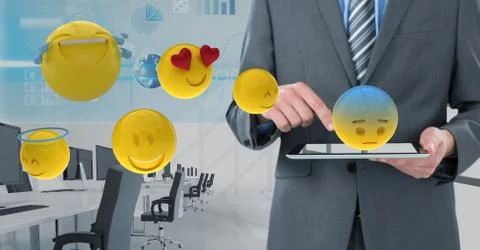 Midsection of businessman using digital tablet with 3d various emojis 스톡 사진