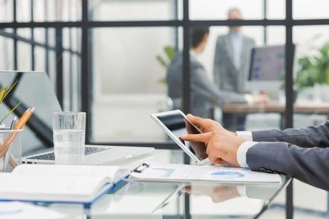 Midsection of businessman using digital tablet in office. Stock Photos