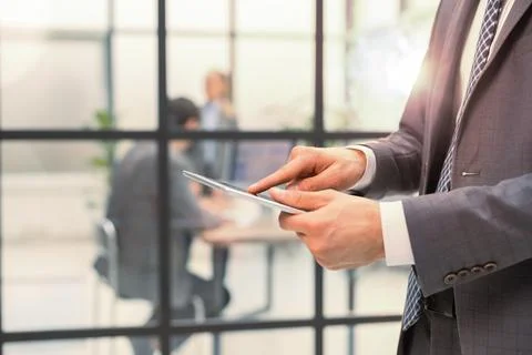 Midsection of businessman using digital tablet in office. Stock Photos