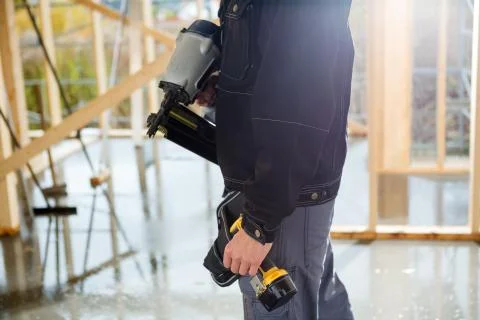 Midsection Of Carpenter With Drill Machines At Site 写真素材