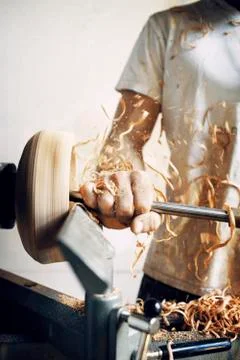 Midsection of carpenter holding chisel while shaping bowl at workshop Stock Photos