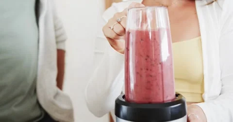 Midsection of caucasian couple preparing heathy smoothies in kitchen, slow Stock-Footage 241979118