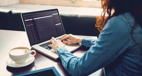Midsection of caucasian female programmer sitting at desk and using laptop with 写真素材