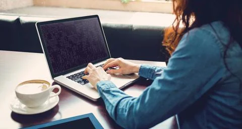 Midsection of caucasian female programmer sitting at desk and using laptop with 写真素材